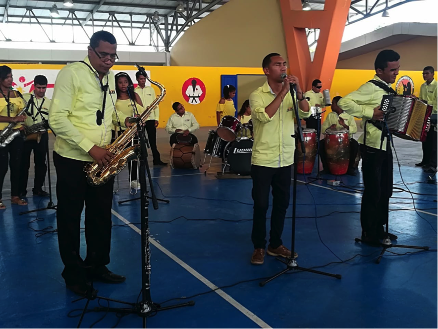 Photograph showing musicians performing with saxophones, drums and singing