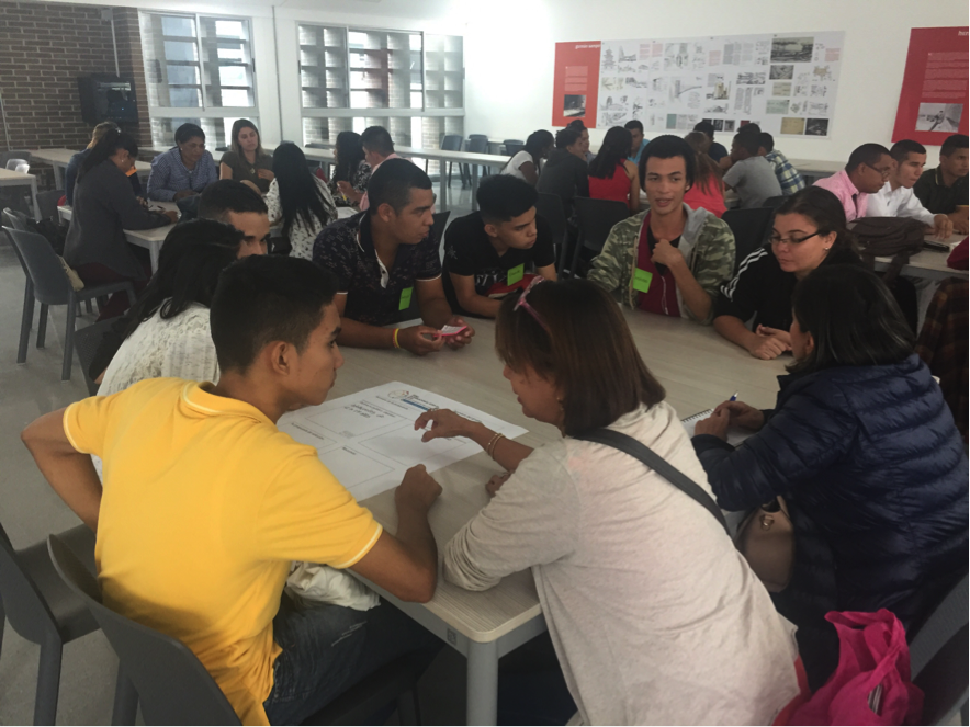 Photograph showing several particpants sitting together around a table and having a discussion